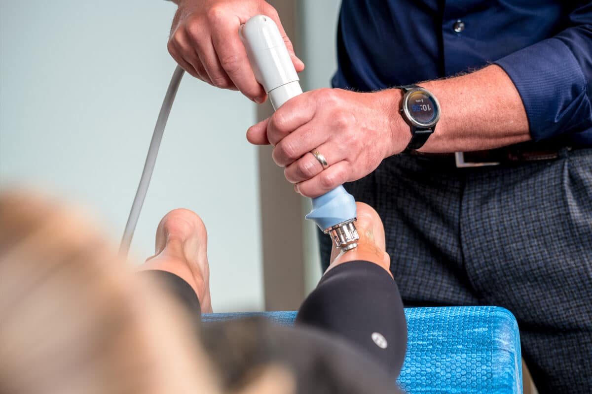 Shockwave treatment on the calves and Achilles tendon at Calgary Core Physio